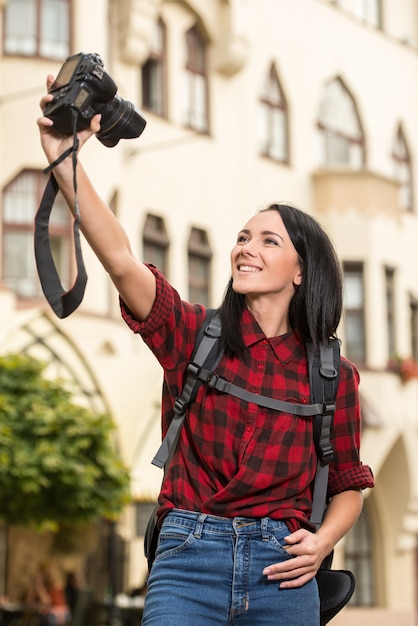 Jovem mulher na cidade está tomando selfie.