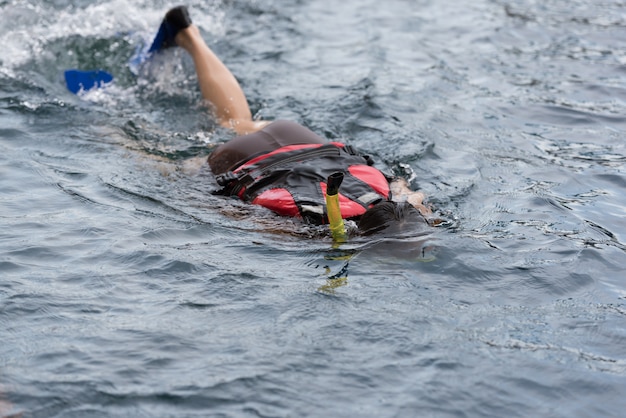 Jovem mulher nadando debaixo d&#39;água na piscina usando snorkel e sapatos de mergulho (movimentação de chinelos, sapatos de mergulho).