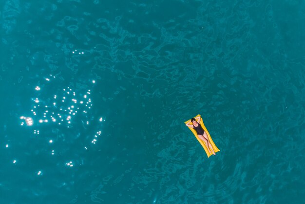 Jovem mulher nadando nas férias de verão de água azul azul