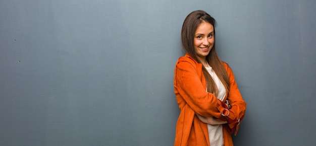 Jovem mulher natural cruzando os braços, sorrindo e relaxada