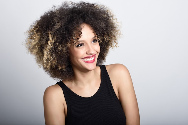 Jovem, mulher negra com afro penteado sorrindo