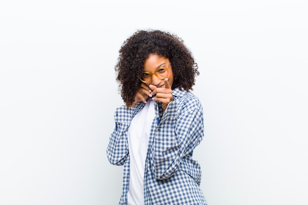 Jovem mulher negra com uma parede branca de telefone inteligente