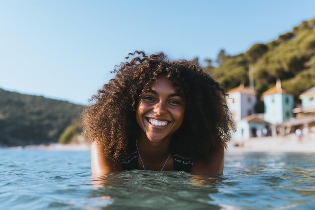 Jovem mulher negra nadando no mar cabelo afro loiro sorrindo férias de verão na Europa