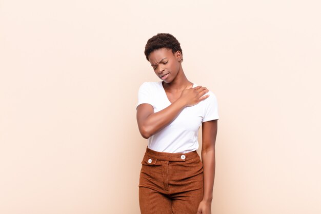 Foto jovem mulher negra se sentindo cansada, estressada, ansiosa, frustrada e deprimida, sofrendo com dores nas costas ou no pescoço