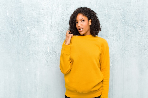 Foto jovem mulher negra se sentindo estressado, ansioso, cansado e frustrado, puxando o pescoço da camisa, parecendo frustrado com o problema