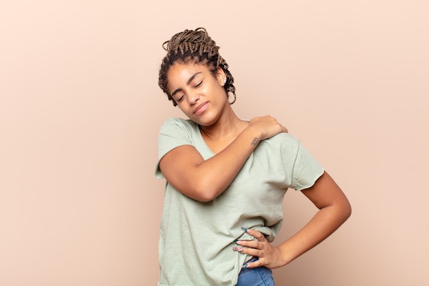 Foto jovem mulher negra sentindo-se cansada, estressada, ansiosa, frustrada e deprimida, sofrendo de dores nas costas ou no pescoço