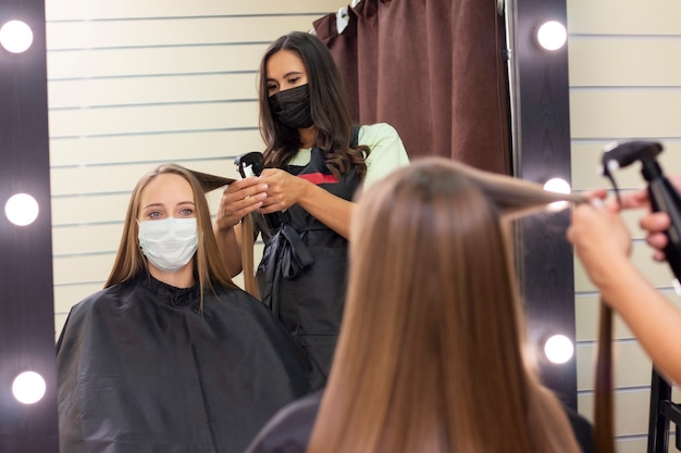 Jovem mulher no cabeleireiro usando máscara protetora