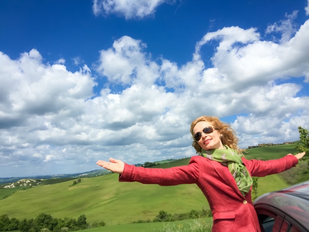 Jovem mulher no carro Freedom in spring field Férias de verão e conceito de viagens