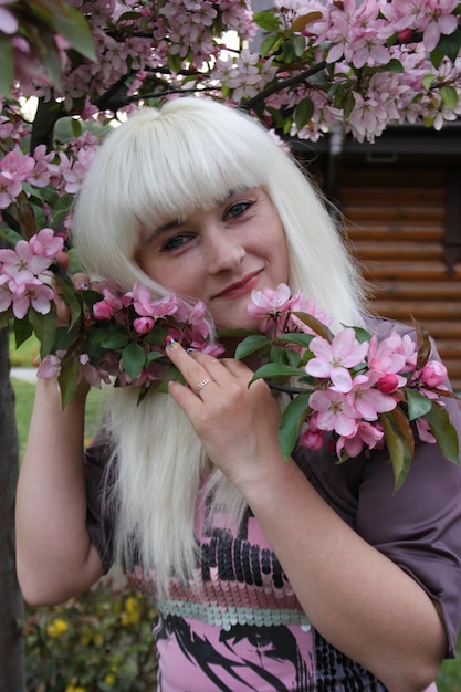 jovem mulher no jardim de flores na primavera. retrato feminino