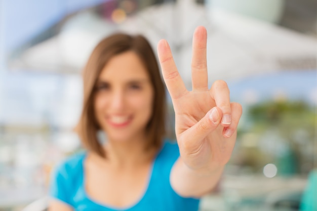 jovem mulher número dois sinal contra o fundo da empresa