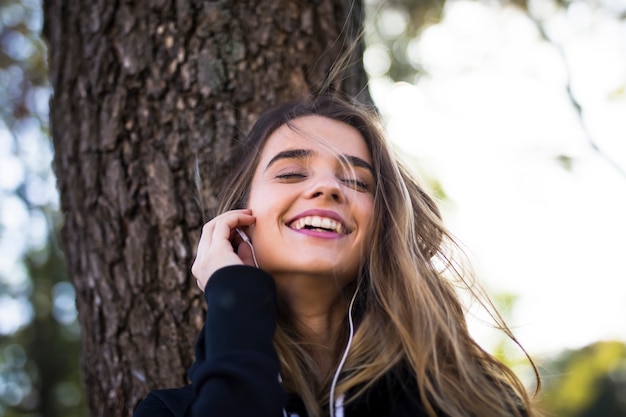 Jovem mulher ouvindo música ao ar livre