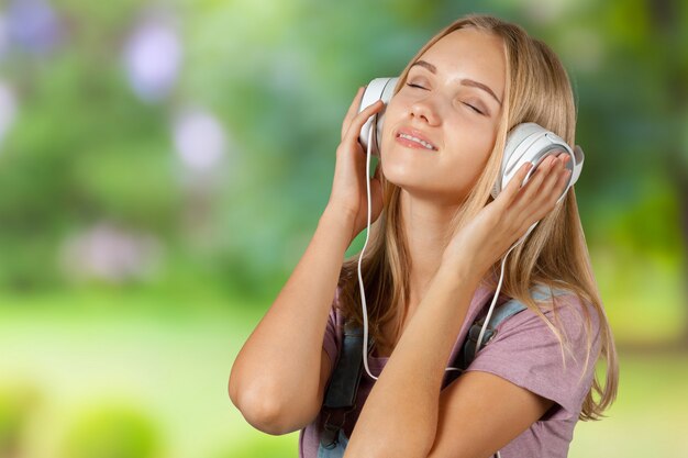 Jovem mulher ouvindo música com fones de ouvido