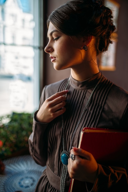 Jovem mulher parada dentro de um café