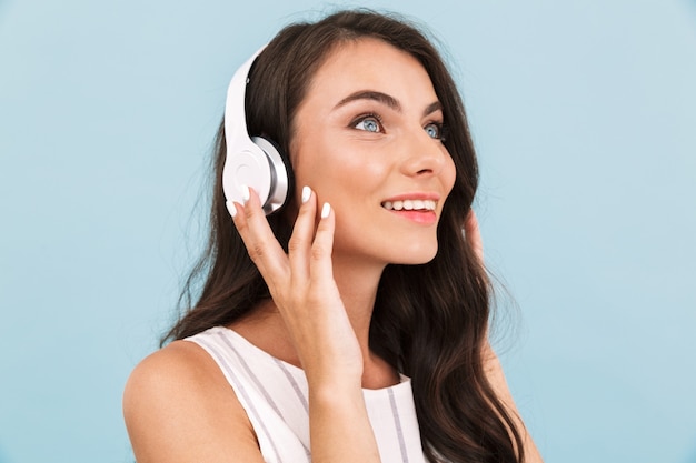 Jovem mulher posando de música de parede isolada com fones de ouvido.