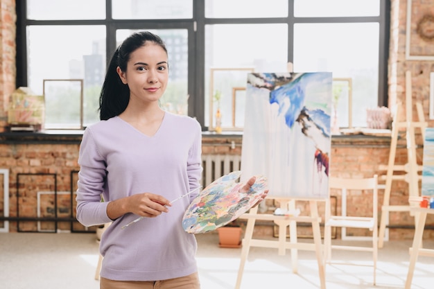 Jovem mulher posando no estúdio de arte