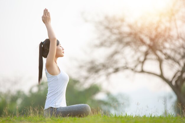 Jovem mulher praticando ioga no parque ao ar livre. Meditação.
