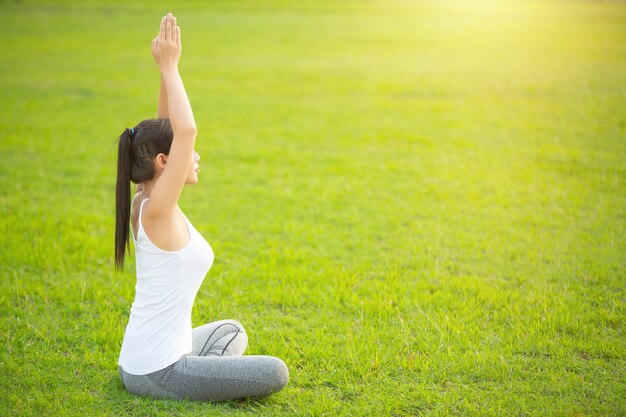 Jovem mulher praticando ioga no parque ao ar livre. meditação.