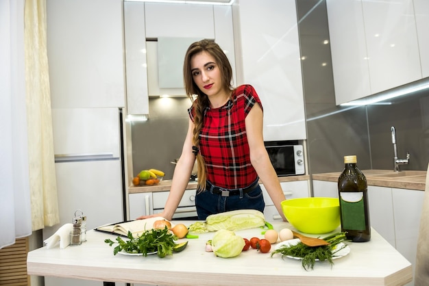 Jovem mulher preparando o jantar em uma cozinha. estilo de vida saudável.
