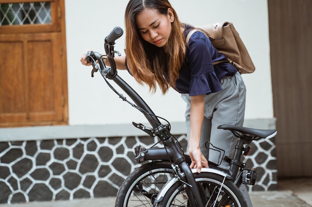 Foto jovem mulher preparando sua bicicleta dobrável