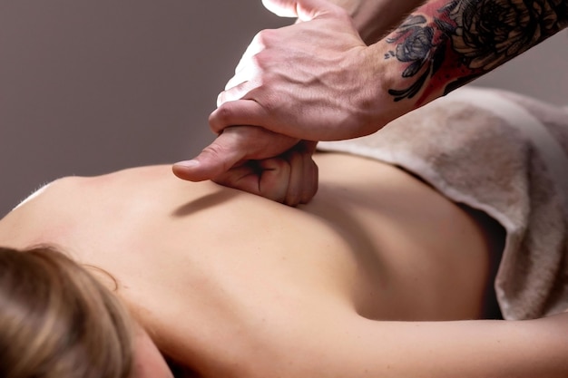 Jovem mulher recebendo uma massagem nas costas em um centro de spa. Paciente do sexo feminino está recebendo tratamento por terapeuta profissional.