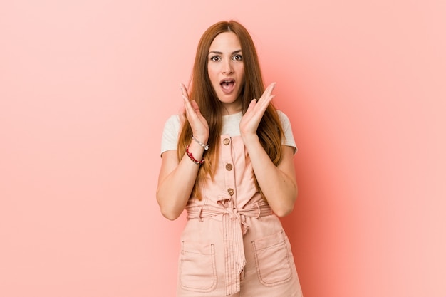 Jovem mulher ruiva com sardas surpreendida e chocada.