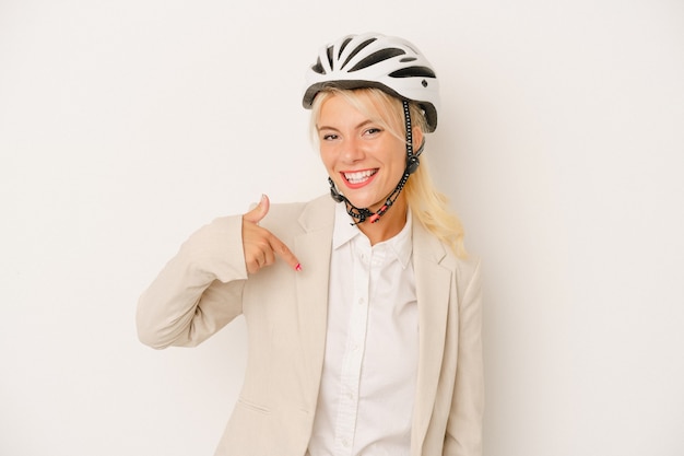 Jovem mulher russa de negócios segurando capacete de bicicleta isolado no fundo branco pessoa apontando com a mão para um espaço de cópia de camisa, orgulhoso e confiante