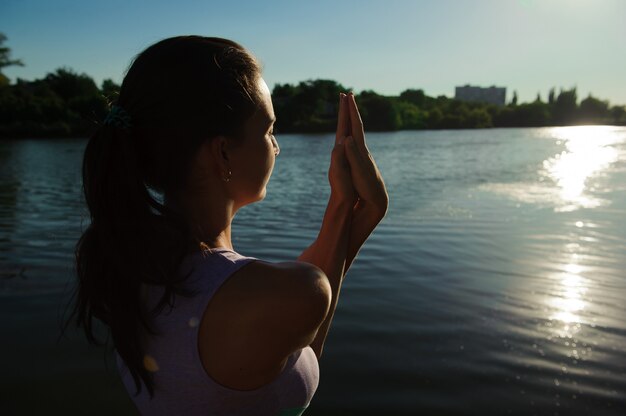 Foto jovem mulher saudável praticando ioga na ponte na natureza.