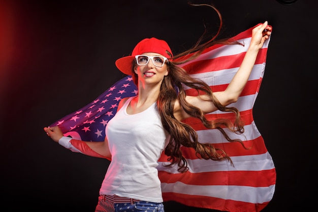 Foto jovem mulher segurando a bandeira americana