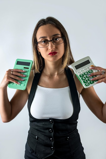 Jovem mulher segurando a calculadora e sorrindo ou pensando isolada no fundo azul