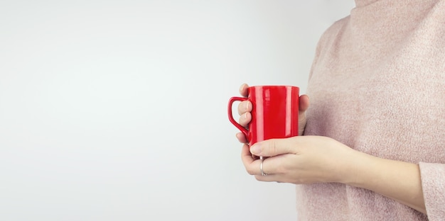 Jovem mulher segurando a xícara de café na mão. bom dia, conceito.