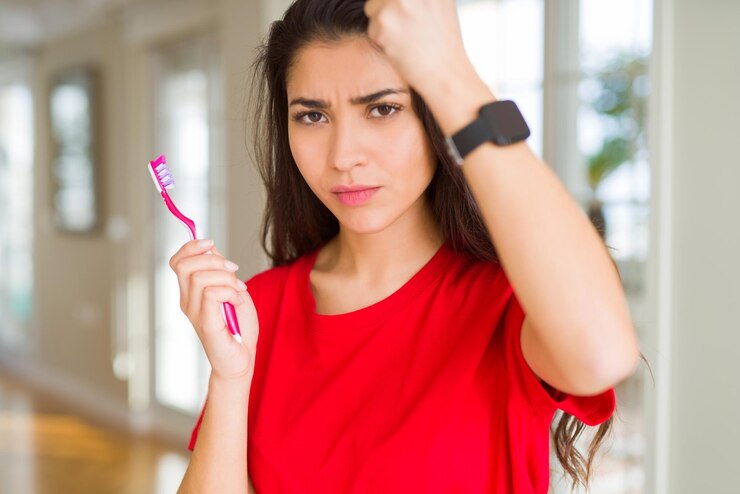 Foto jovem mulher segurando escova de dentes irritada e frustrada gritando com raiva louca e gritando com o conceito de raiva de mão erguida