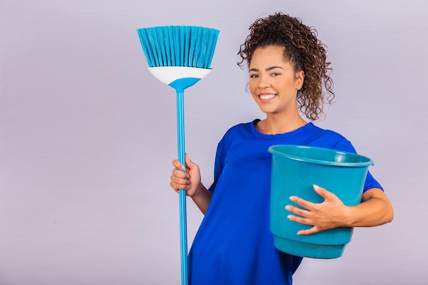 Jovem mulher segurando ferramentas de limpeza isoladas em branco. Mulher de dona de casa. Limpador.