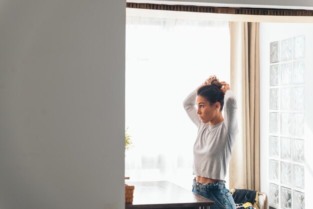 Foto jovem mulher segurando o cabelo em uma sala