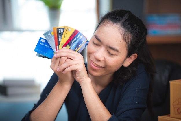 Jovem mulher segurando o cartão de crédito e usando o computador portátil. conceito de compras online