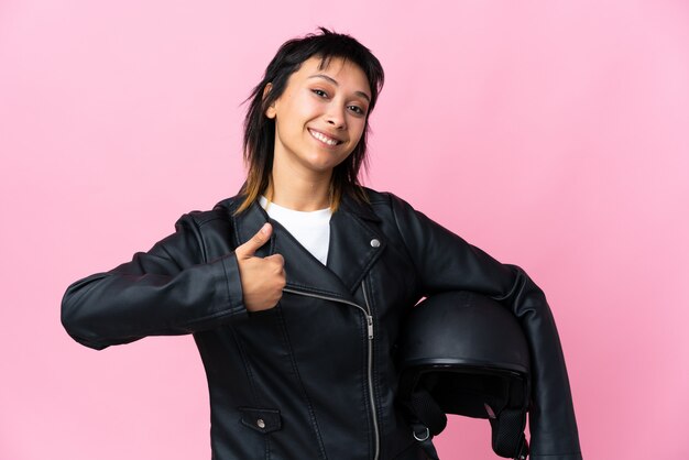 Jovem mulher segurando um capacete de moto isolado rosa dando um polegar para cima gesto