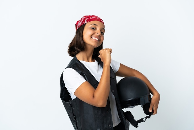 Jovem mulher segurando um capacete de motociclista isolado no branco, orgulhosa e satisfeita