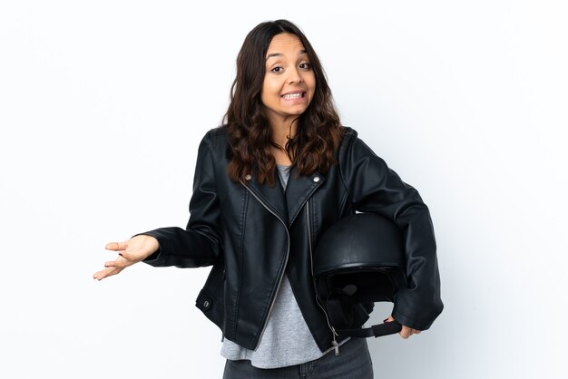 Jovem mulher segurando um capacete de motociclista sobre um fundo branco isolado sorrindo