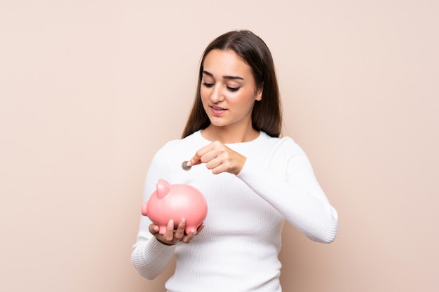 Jovem mulher segurando um grande piggybank