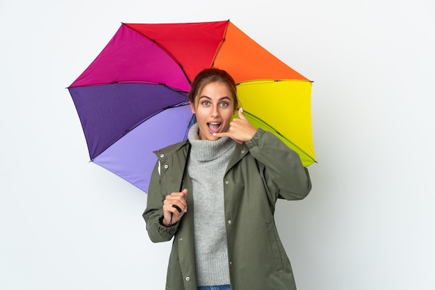 Jovem mulher segurando um guarda-chuva posando isolada contra a parede em branco