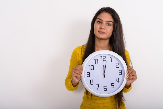 Foto jovem mulher segurando um relógio de parede mostrando as horas