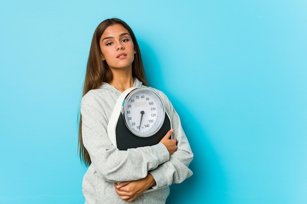 Jovem mulher segurando uma balança