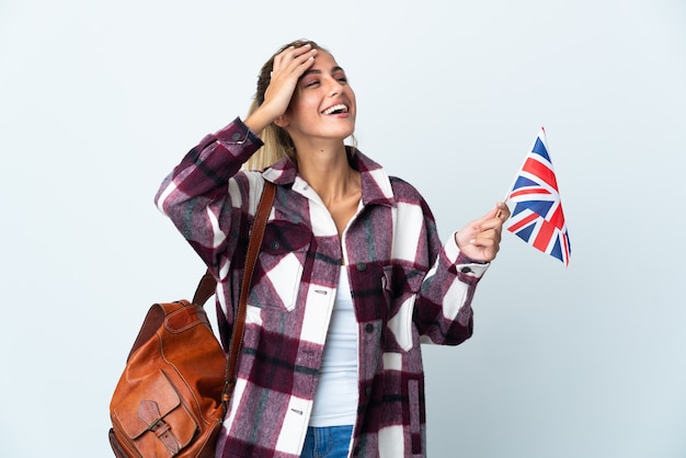 Jovem mulher segurando uma bandeira do Reino Unido isolada sorrindo muito