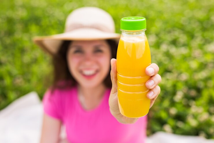 Foto jovem mulher segurando uma garrafa com suco.