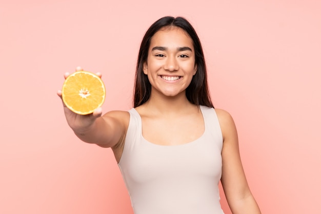 Jovem mulher segurando uma laranja