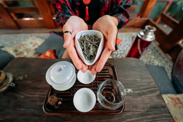 Jovem mulher segurando uma pequena tigela de chá verde de ervas