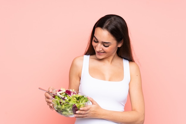 Jovem mulher segurando uma salada rosa