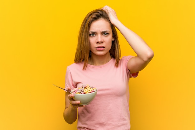 Jovem mulher segurando uma tigela de cereais sendo chocado