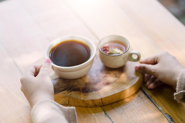 Jovem mulher segurando uma xícara de café quente na vista da natureza