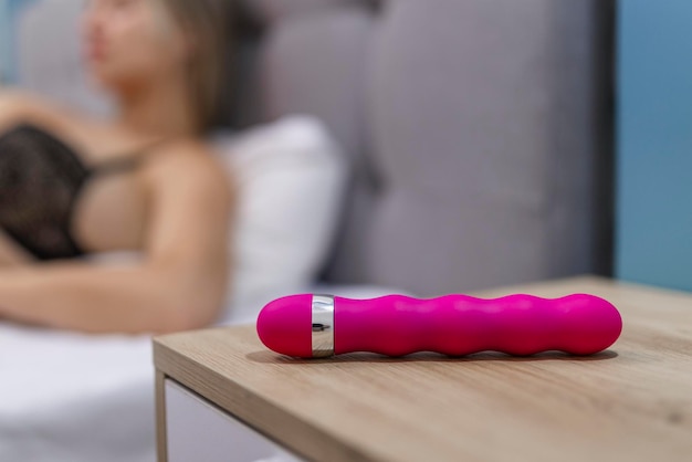 Jovem mulher segurando vibrador vibrador de brinquedo sexual na cama