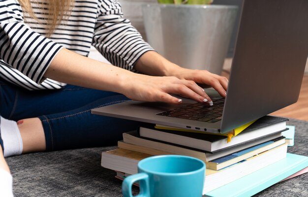 Jovem mulher sentada no chão com o laptop dela